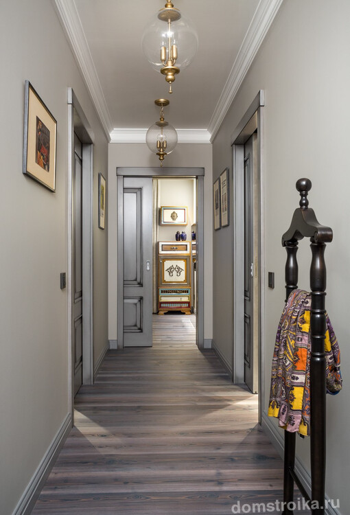 Узкий коридор в нейтральных светлых тонах отлично подойдет для объединения разноплановых комнат в квартире