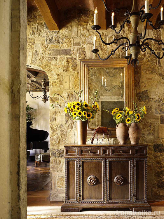 Каменная стена и открытые балки в прихожей, оформленной в стиле средневековой Франции