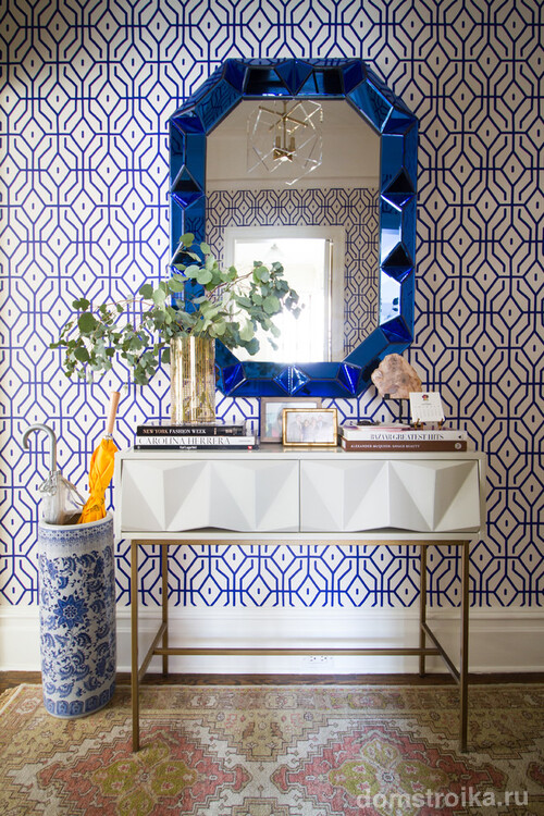 Синий узор на белых обоях в коридоре дополняет синяя рамка зеркала и сине-белая ваза под старинный фарфор для зонтов