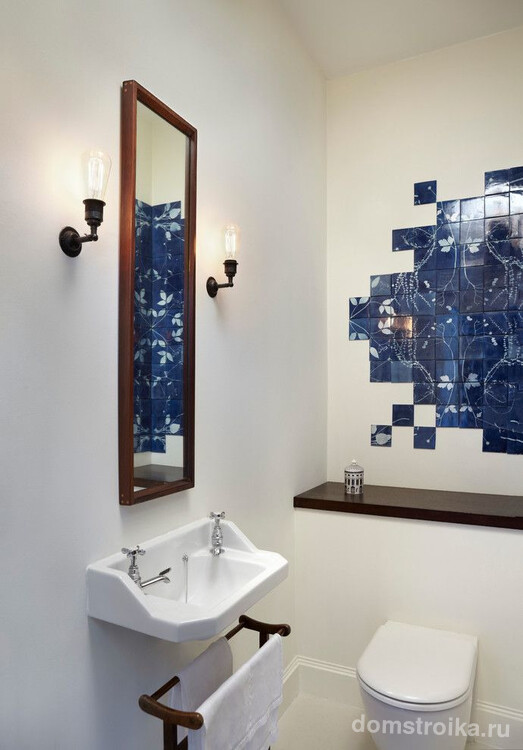 Панно из темно-синей плитки контрастирует на фоне белой ванной
