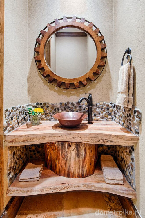 Небольшая медная раковина в деревянной столешнице в средиземноморском интерьере ванной комнаты