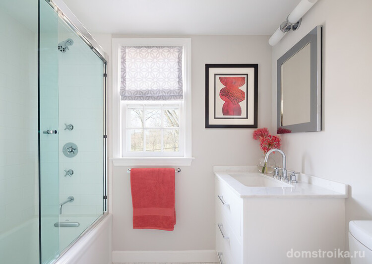 Очень аккуратная ванная комната с легкой стеклянной раздвижной шторкой и нежными розовыми акцентами на элементах декора