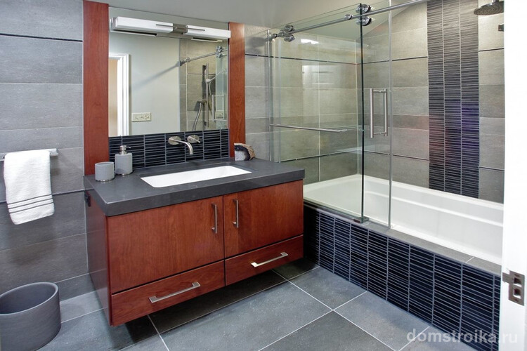 Большая стеклянная шторка для ванной в серых тонах с акцентом на отделке мебели натуральным деревом