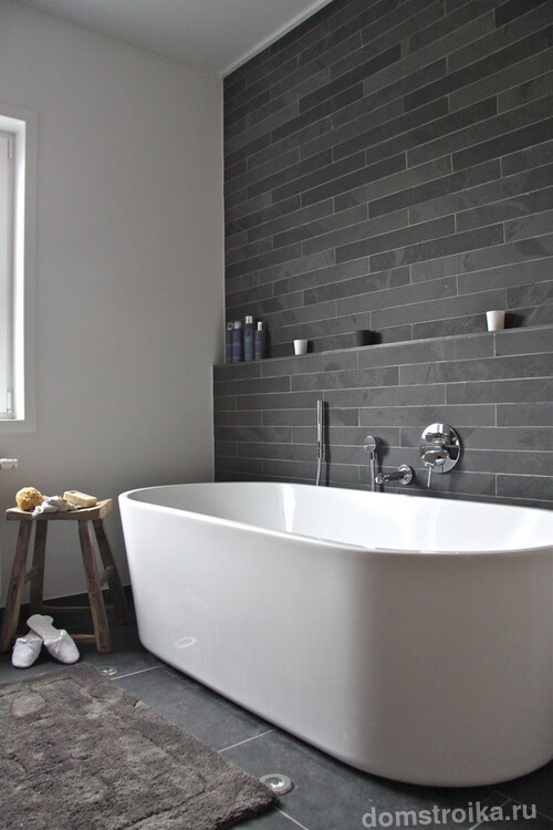 Темно-серая матовая плитка под камень на одной из стен современной ванной комнаты