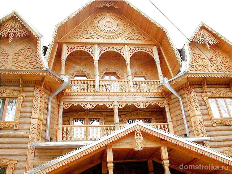 Современный дом со светлого деревянного сруба, украшенный резными наличниками на окнах