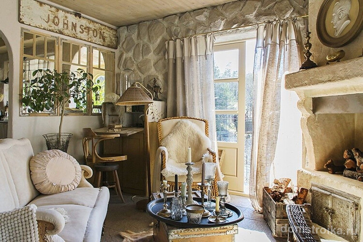 интерьер деревенского дома: уютная гостиная в английском стиле: отделка из натурального камня, светлая мебель, полупрозрачные занавески и камин