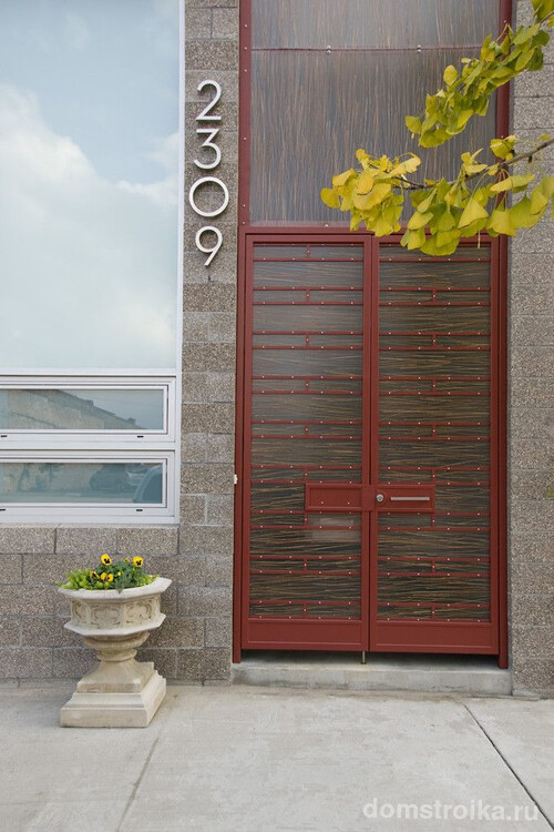Двойные входные двери частного современного дома, одна из которых, пластиковая, является декоративной конструкцией