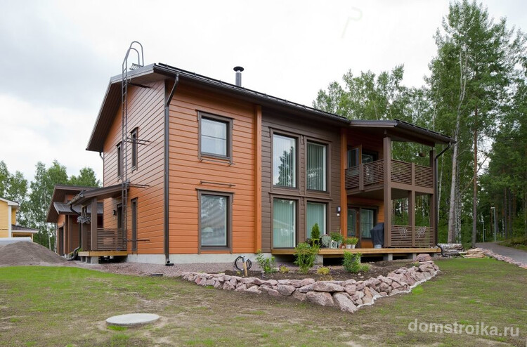 Двухэтажный частный дом из клееного бруса двух оттенков коричневого