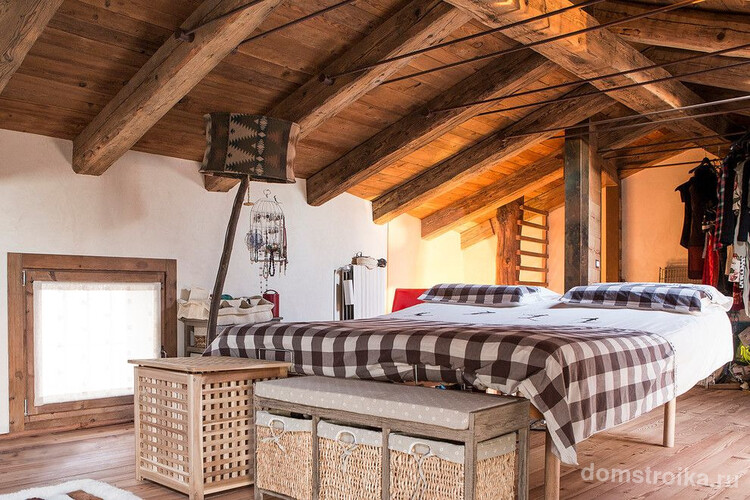 Спальня в деревенском стиле под крышей деревянного дома