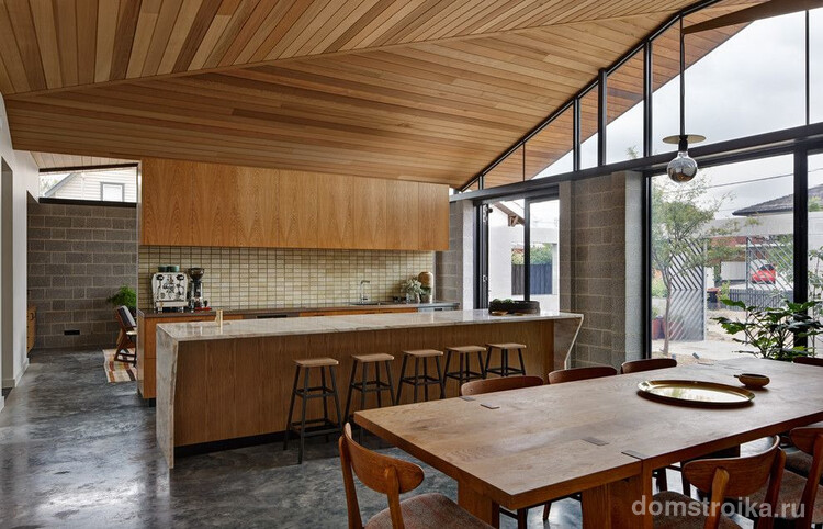 Частный стильный дом с деревянной обшивкой потолка и деревянной мебелью