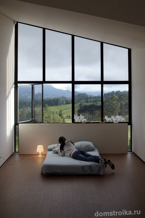 Спальня дома с витражным остеклением фасада с видом на горы
