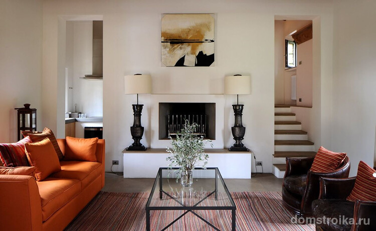 Контраст ярко-оранжевого дивана и коричневых кресел присущи средиземноморскому стилю