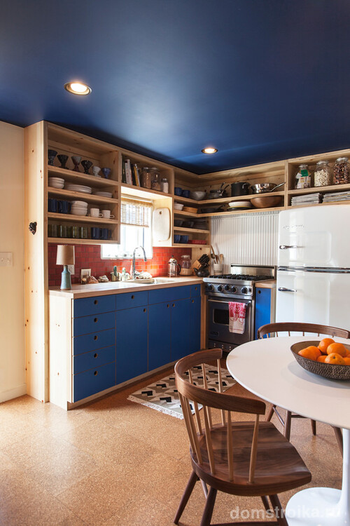 Удачное сочетание синего цвета и деревянной мебели в интерьере кухни
