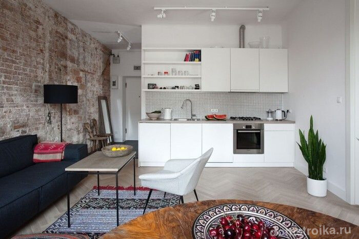 Контраст белого и кирпичной стены в оформлении однокомнатной кухни-студии
