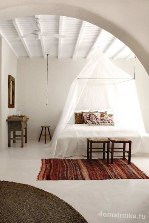 Кровать под прозрачны легких балдахином в белой спальне