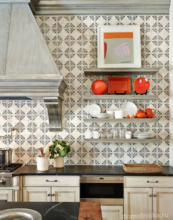 Кухня в испанских мотивах с мозаичной стенкой и ярко-оранжевыми элементами посуды и декора