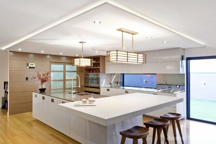 Подвесная потолочная конструкция с подсветкой, белая мебель, светильники с мягким светом делают кухню поистине воздушной