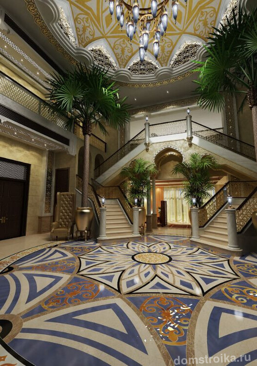 Холл в доме в стиле махараджей: огромные пальмы, высокий куполообразный потолок, лестница и цветочные мотивы на потолке и полу