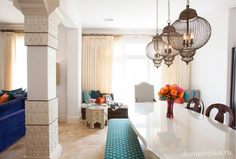 Обеденная зона в марокканском стиле: разделена от гостиной с помощью арочного проема. В качестве декора использованы традиционные подвесные светильники и ваза с цветами
