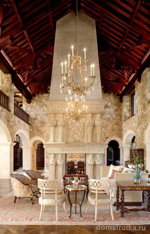 Гостиная в готическом стиле: стрелкообразный бордовый потолок, каменные стены, арки вместо дверей и мраморные антические скульптуры в качестве декора