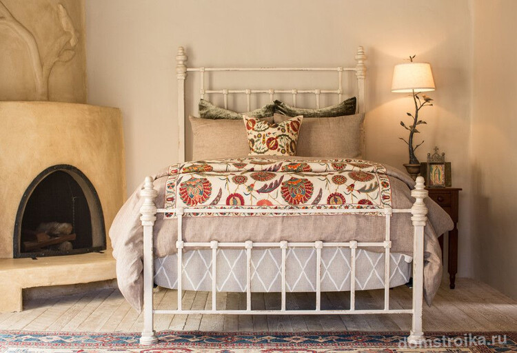 Испанский стиль в интерьере: камин и кованая кровать создают испанский стиль в спальне