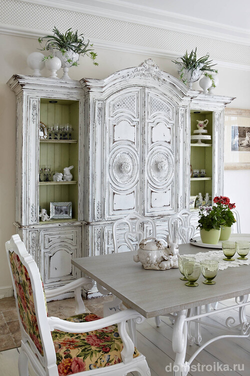 Красивый состаренный шкаф в столовой. Обратите внимание, как красиво контрастируют с белым насыщенные цвета обивки мебели