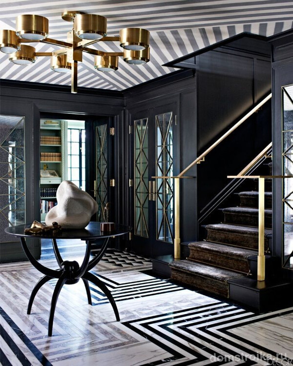 Геометрия на полу и потолке, черно-белая гамма, необычная люстра, лестница - все это выдает стиль арт-деко