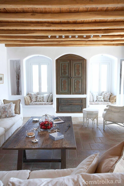Изюминкой гостиной может стать арочный шкаф, а так же уюта помещению добавят подушки на подоконниках с принтом в греческом стиле