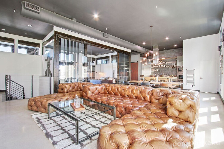 Угловой роскошный диван из кожи в дизайне квартиры-студии
