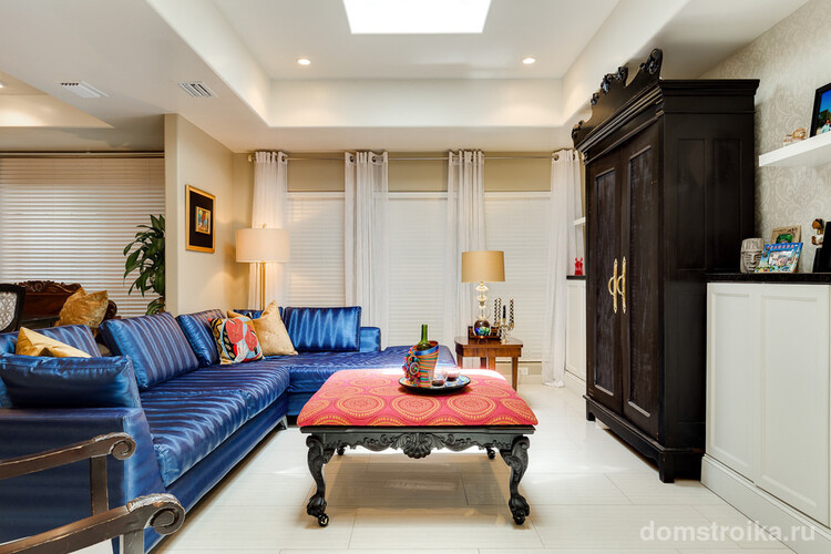 Красивый массивный черный шкаф хорошо сочетается с ярким синим диваном