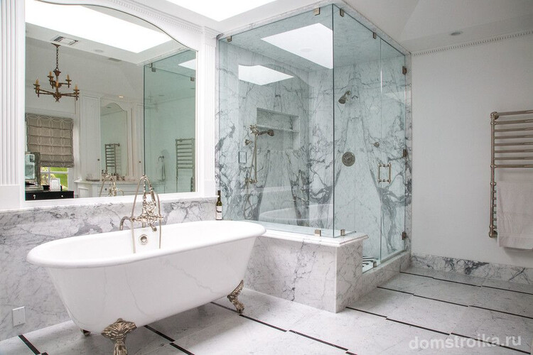 Красивая светлая ванная комната с мраморной отделкой и белыми пилястрами