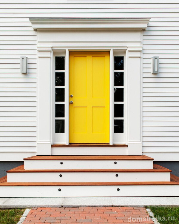 Современный дизайн в оформлении дома с ярко-желтой дверью и минималистичными пилястрами
