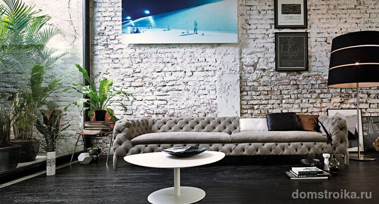 Стильный современный интерьер с большим серым диваном Честерфилд