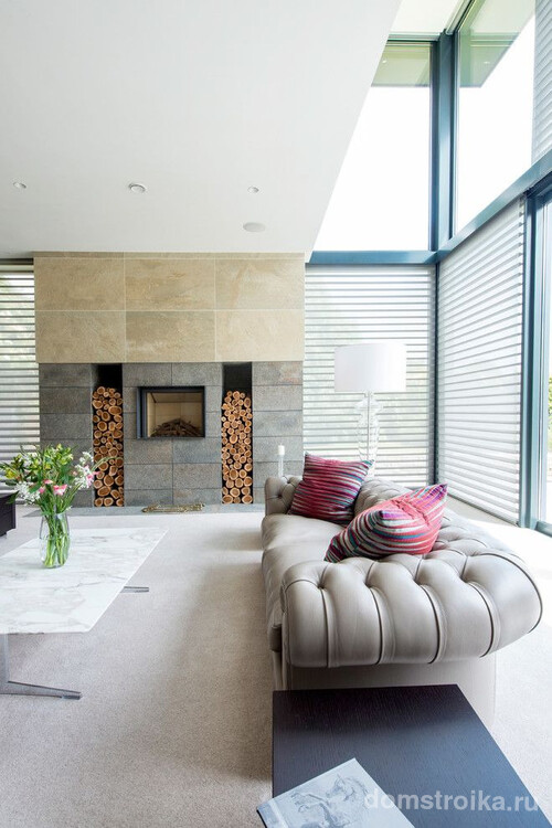 Просторный интерьер гостиной частного дома с серым диваном Честерфилд в современном оформлении
