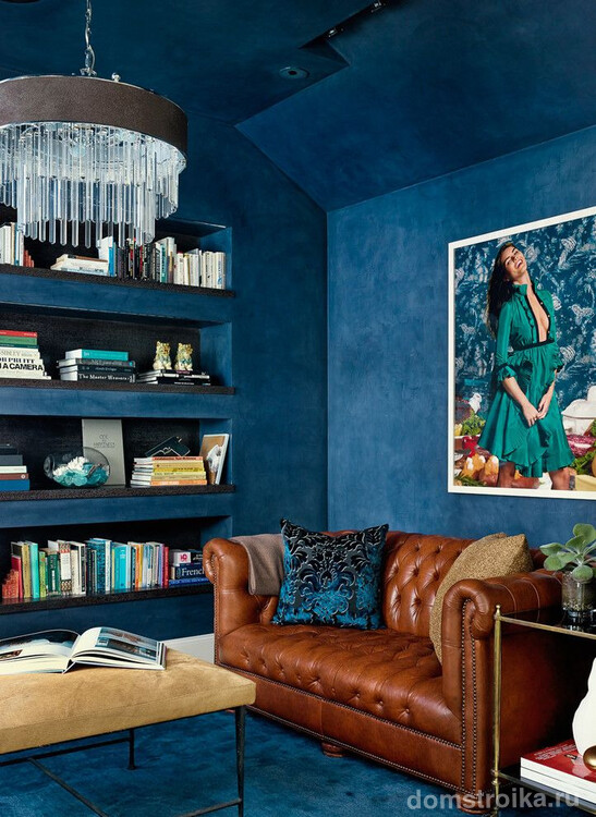 Красивый синий интерьер в стиле фьюжн с небольшим диваном Честерфильд коричневого цвета