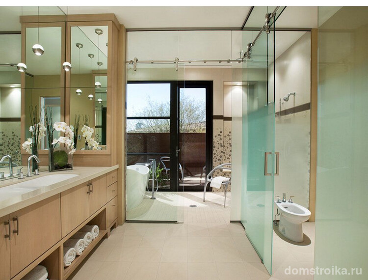 Тумбочки из светлого ясеня, зеркала, прозрачные перегородки добавляют «воздушности» и «легкости» ванной комнате