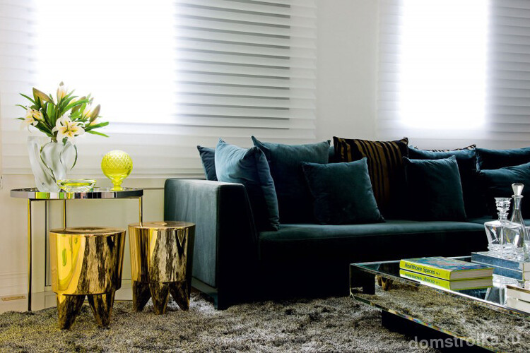 Роскошное сочетание бархатного дивана с золотыми табуретами и, практически незаметным, зеркальным журнальным столиком