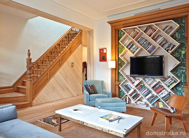 Дизайнерское решение для гостиной загородного дома: полка для телевизора размещена в разрез с диагональными полками для книг