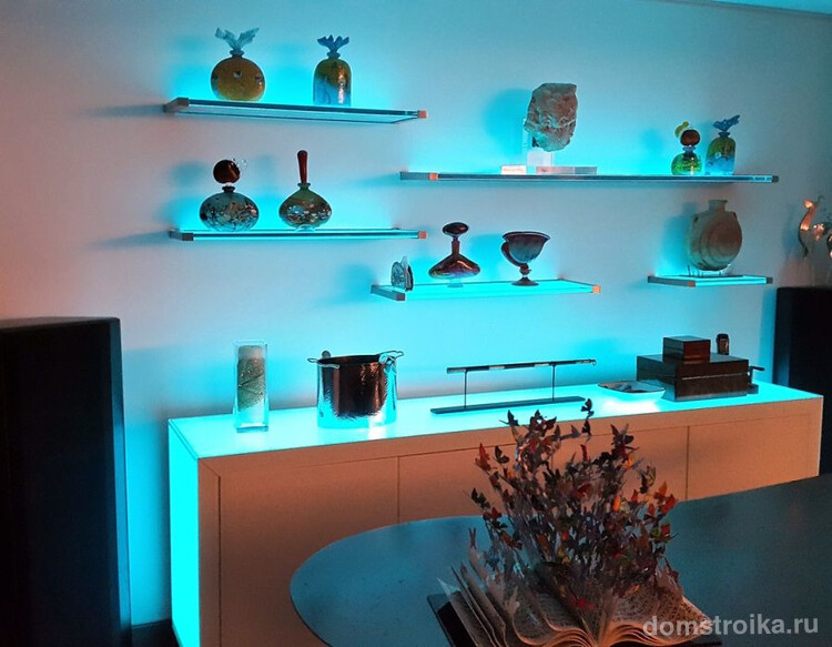Синяя подсветка полок в гостиной способна выгодно изменить очертание предметов декора