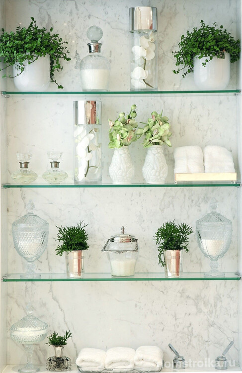 Пример оформления стены в ванной комнате с помощью тонких стеклянных полок, растений и туалетных принадлежностей