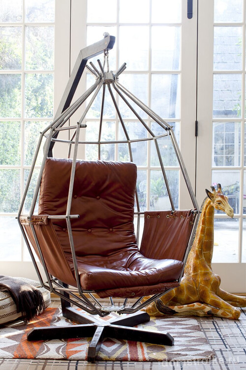 Необычный вариант подвесного кресла из кожи, установленного на подставке