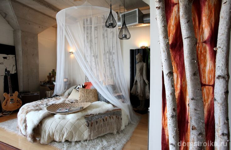 Круглая кровать с прозрачным балдахином посередине комнаты в скандинавском стиле