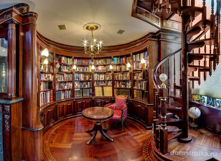 Темное дерево, необычное размещение стеллажей, удобное кресло в королевском стиле – все эти детали придают библиотеке очень богатый вид