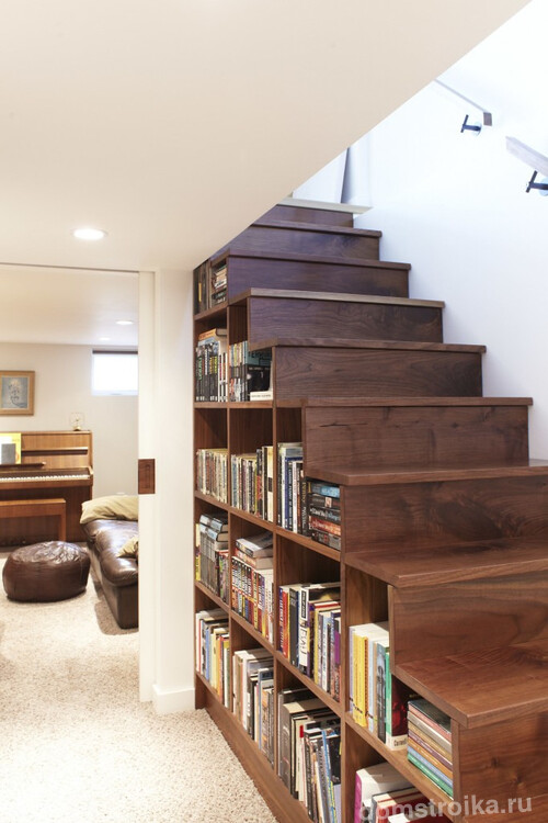 Значительно сэкономить место вы сможете разместив книжный шкаф под лестницей