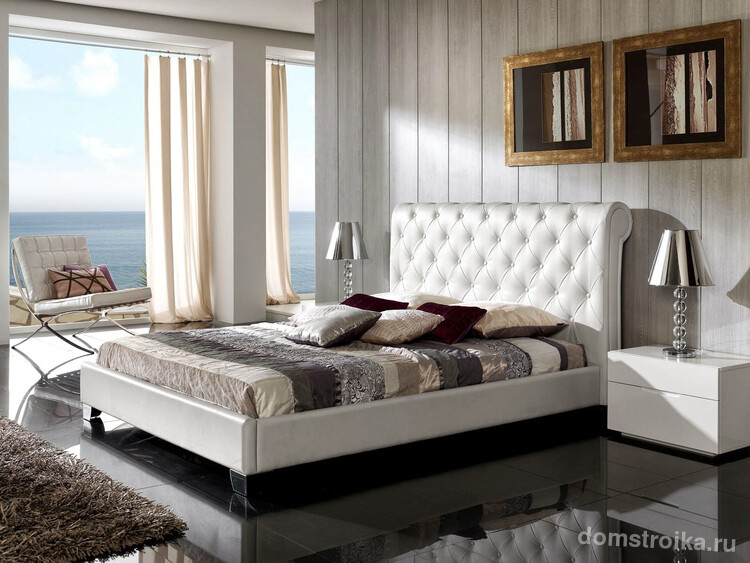 Кровать и кресла в спальне изготовлены из белой кожи