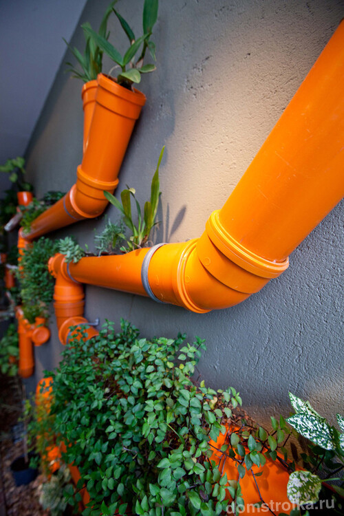 Трубы ярко-оранжевого цвета с растениями - необычная композиция способная преобразить интерьер