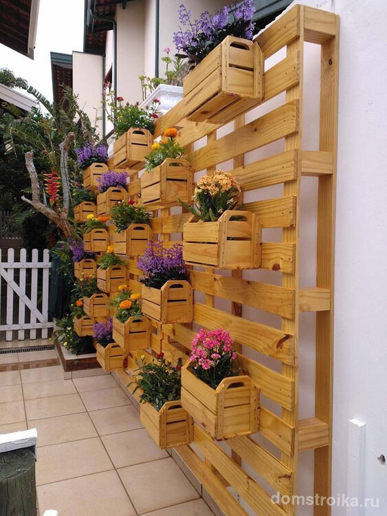 Деревянная конструкция с ящичками, куда можно выставлять цветы в горшках и наслаждаться общим видом цветущей стенки