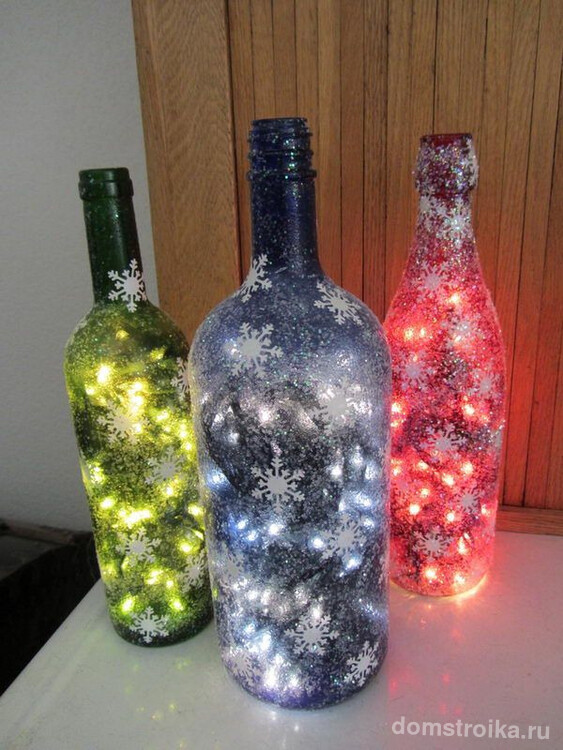 С помощью цветной гирлянды и бутылки можно создать такой необычный элемент декора