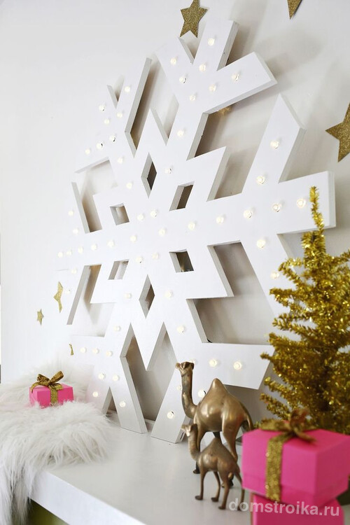 Большая снежинка из дерева, украшенная лампочками, задаст новогоднее настроение всем домочадцам
