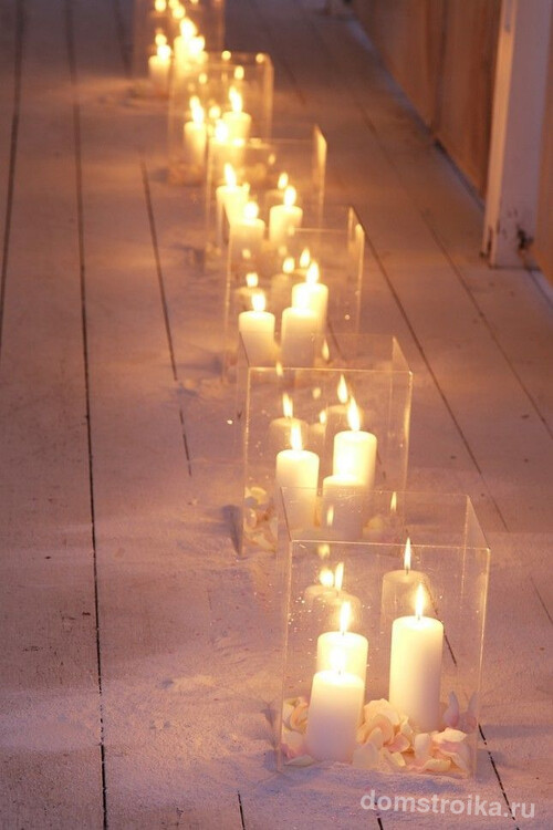 Романтическая обстановка с помощью напольных свечей в широких стеклянных ёмкостях